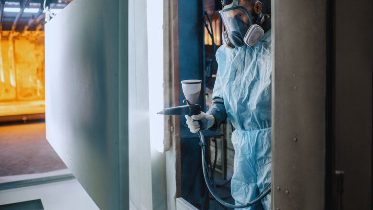 Man Spraying Powder onto Metal