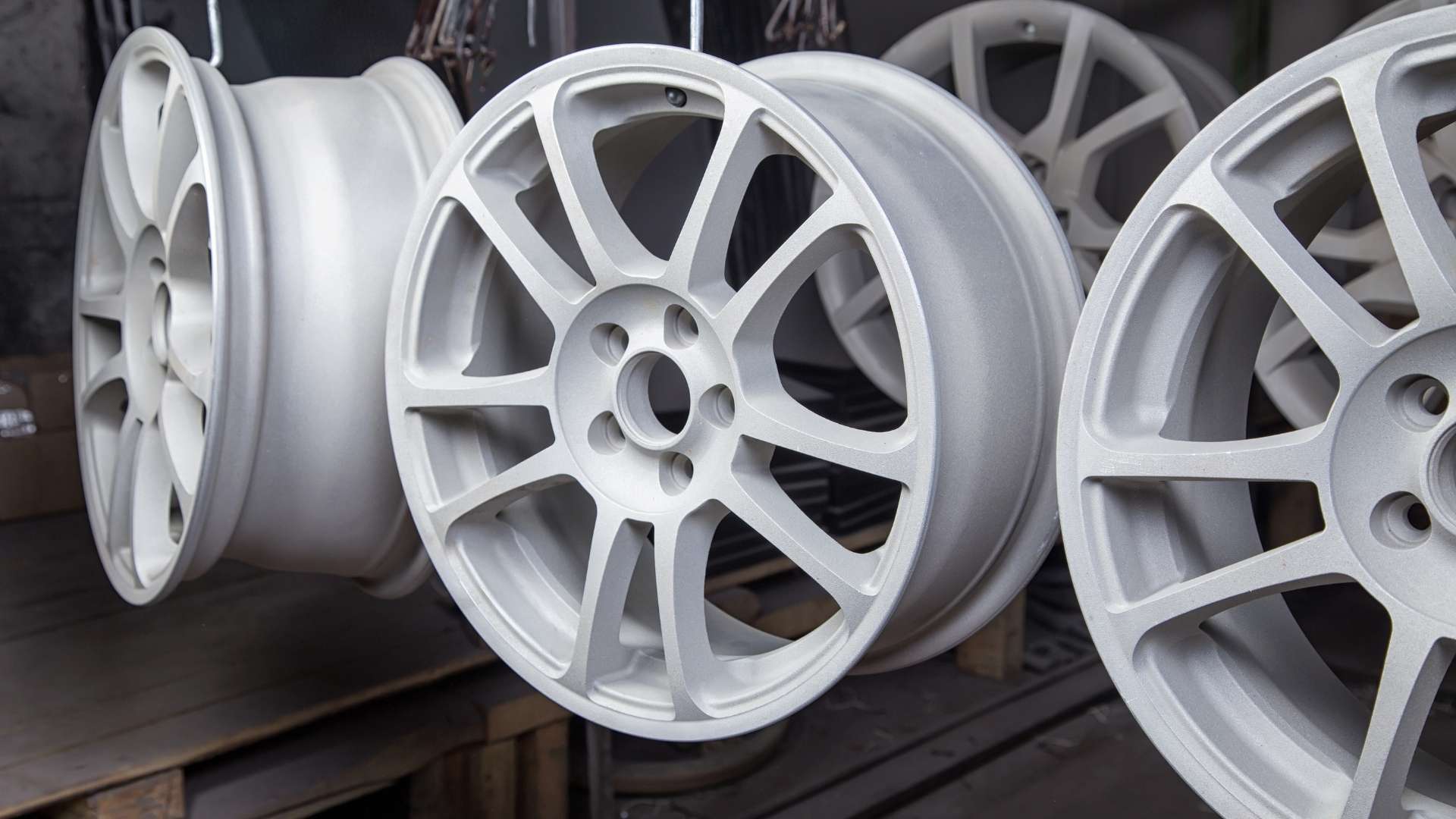 white rimmed wheels drying on rack from recent powder coating